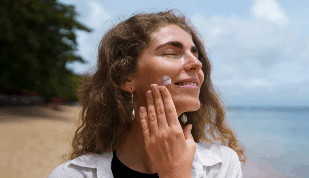 Persona aplicándose protector solar sobre el rostro al aire libre