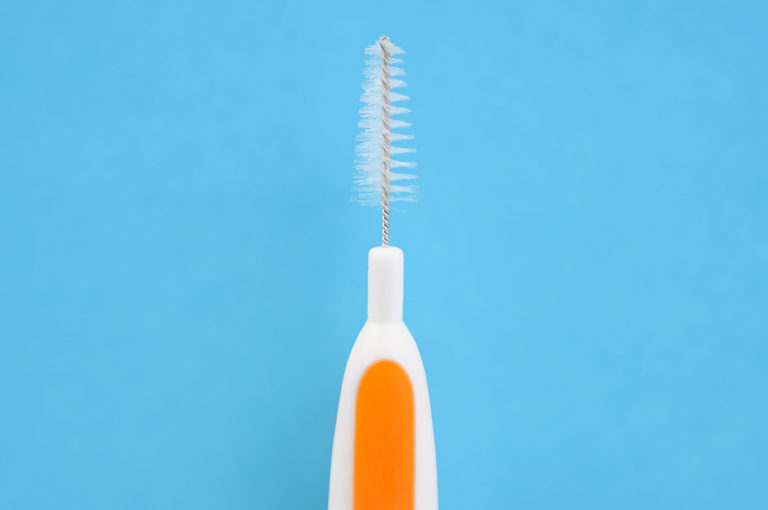 Cepillo de dientes interdental en fondo azul