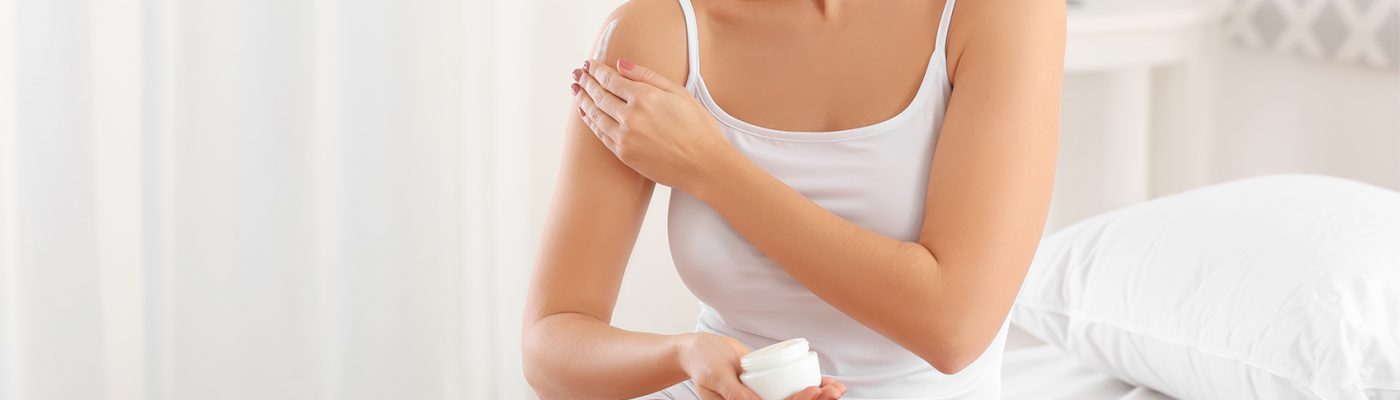 Mujer aplicándose producto en el cuerpo.psd